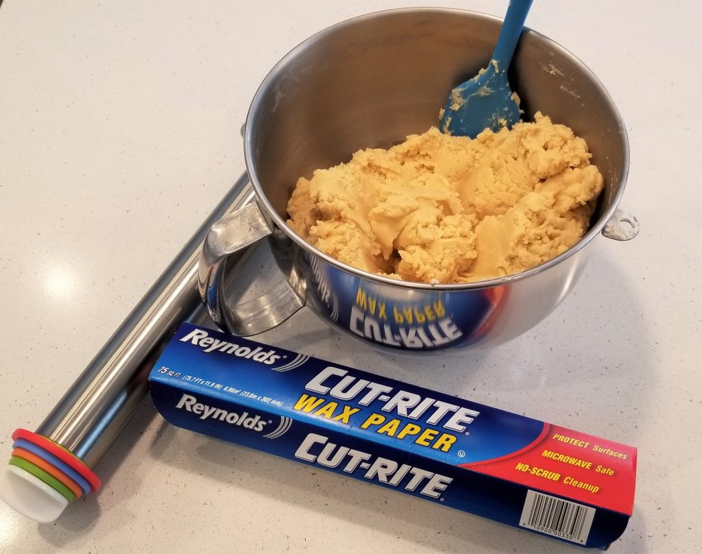 Wax Paper, Rolling Pin with Guide Rings and Soft No-Spread Sugar Cookie dough ready to be rolled out.