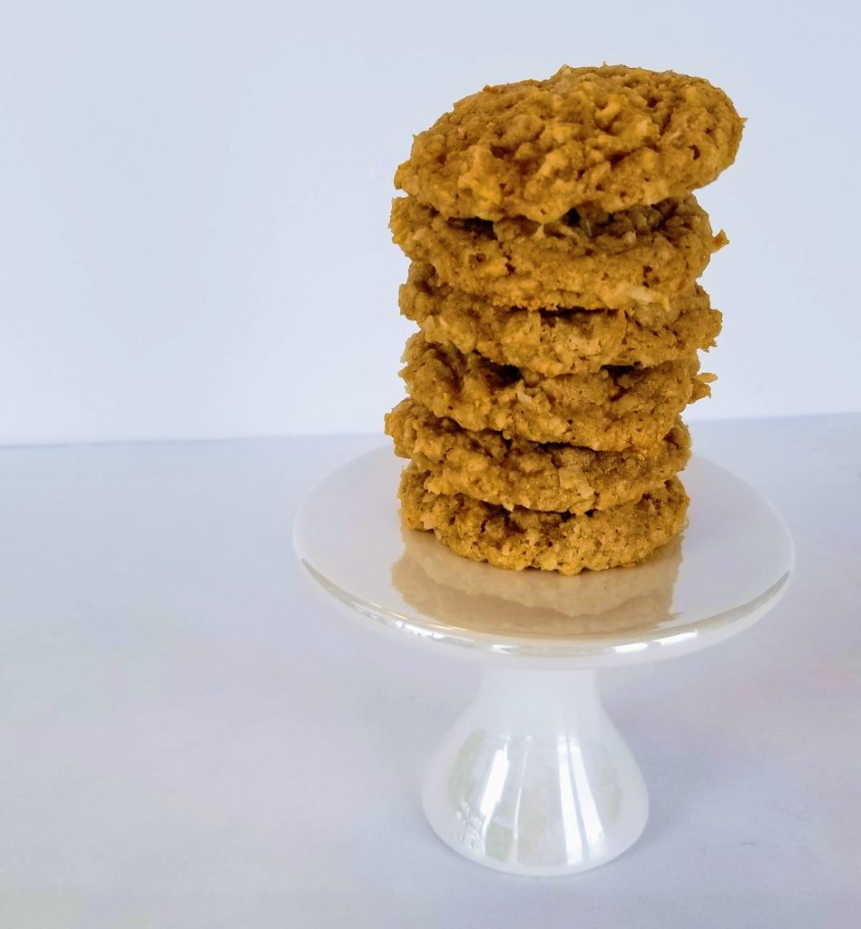 Stacked Chewy Coconut Oatmeal Cookies on a small Cake Stand