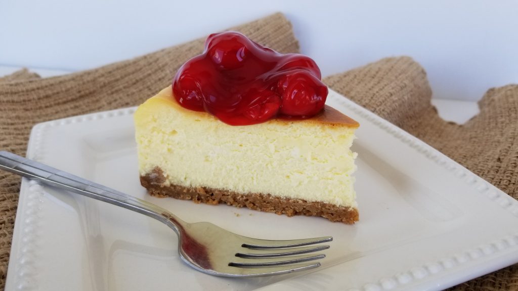 Slice of Classic New York Style Cheesecake with Cherry Pie Filling